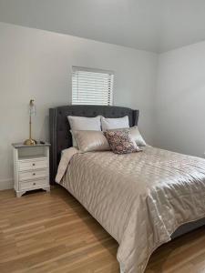 休斯顿Stylish, 2 Bedroom in Houston-Bellaire的一间卧室配有一张带床头柜的床和一张四柱床。