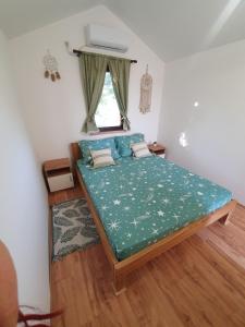 TemerinBungalov Lenka的一间卧室配有一张带绿色棉被的床和窗户。