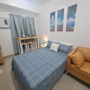达斯马里尼亚斯Homely Green 2 Residences T2的一间卧室配有蓝色的床和沙发
