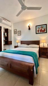 圣玛尔塔Camali Hotel的一间卧室配有一张大床和吊扇