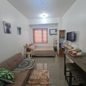 达斯马里尼亚斯HOMELY @ Green 2 Residences SMDC DLSUMC的客厅配有沙发和1张床