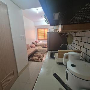 达斯马里尼亚斯HOMELY @ Green 2 Residences SMDC DLSUMC的带沙发的厨房和客厅
