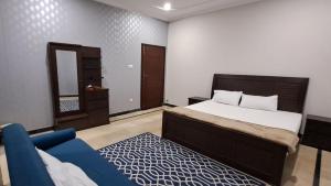 伊斯兰堡Islamabad Layover Guest House Free Airport Pick and Drop的一间卧室配有一张床和一张蓝色的沙发