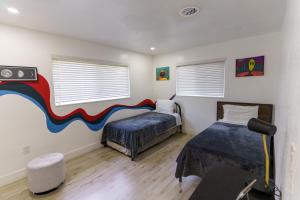 迈阿密CryptoCabana的一间卧室设有两张床,墙上挂着一幅画
