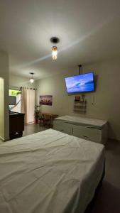 乌巴图巴Área vip maranduba的一间卧室配有一张床和一台平面电视