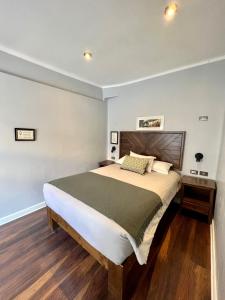 库斯科Casa Montes San Blas的一间卧室配有一张大床和木制床头板