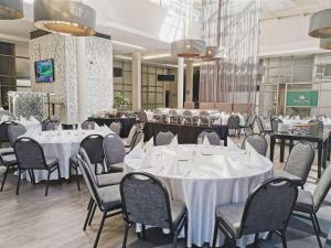 开普敦开普顿上东区希尔顿逸林酒店的一间设有白色桌椅的用餐室