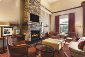 米斯蒂克米斯提希尔顿恒庭旅馆&套房酒店的客厅设有壁炉和沙发。