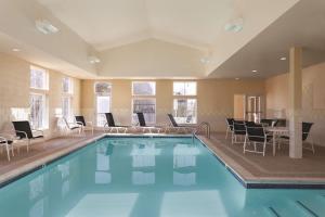 米斯蒂克米斯提希尔顿恒庭旅馆&套房酒店的一个带椅子和桌子的大型游泳池