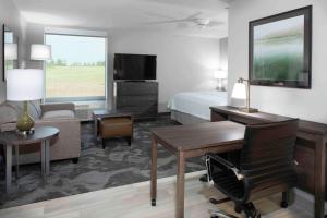 兰辛Homewood Suites By Hilton Lansing Eastwood的酒店客房设有一间带一张床和一张书桌的卧室