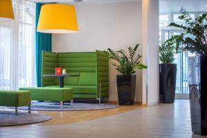 纽伦堡纽伦堡雷迪森公园客栈的绿沙发,带桌子和植物的房间