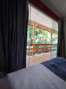 布卢梅瑙Castelo de Madeira的一间卧室设有一张床和一个大型玻璃窗