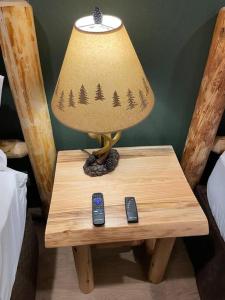 格兰茨帕斯Cedar Mountain Suite D的桌子上的一盏灯,有两个遥控器