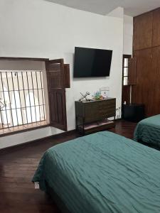 SantiagoCasa Praxedis的酒店客房设有两张床和一台平面电视。