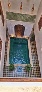 马拉喀什Riad Belikoss Pool & SPA的一座大型游泳池,位于一座铺有瓷砖地板的房屋内