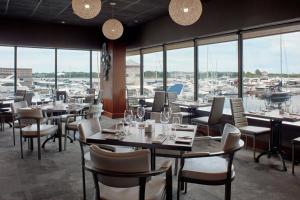 金斯顿三角洲金斯顿海滨万豪酒店的一间带桌椅的餐厅和一个码头