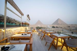 开罗大金字塔酒店 的餐厅设有桌子,后面还有金字塔