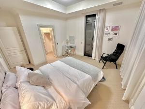 布里斯班麦克阿瑟钱伯斯酒店的白色卧室配有床和椅子