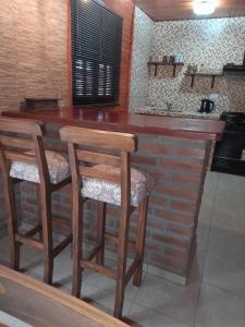 蒂诺加斯塔Cabañas Edna的厨房设有带2张凳子的木制酒吧