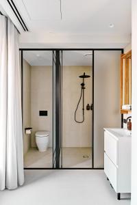 墨尔本Central Club Hotel - North Melbourne的浴室设有玻璃淋浴间和卫生间
