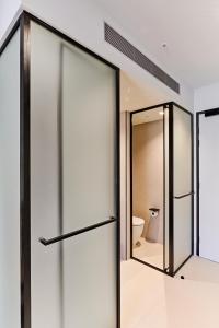 墨尔本Central Club Hotel - North Melbourne的浴室设有滑动玻璃门和卫生间。