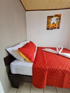 福尔图纳Cabins Guayabon #2, Arenal Volcano La Fortuna的一间卧室配有两张红色和白色床单