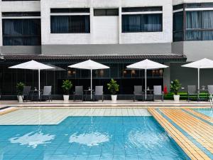 吉隆坡The Bed Bukit Bintang的一个带遮阳伞和桌椅的游泳池
