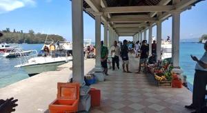 八丹拜Gilibooking ticket的一群人站在码头上,坐船