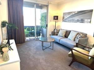 阿德莱德Adelaide Dress Circle Apartments - Archer Street的客厅配有沙发和桌子