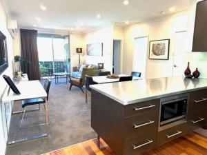 阿德莱德Adelaide Dress Circle Apartments - Archer Street的一个带厨房的大客厅和一间客厅