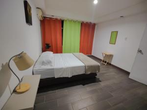 圣何塞Casa Escalante Hostel的一间设有床和多彩窗帘的房间
