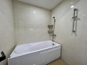河内NINE HOUSING Buoi Street的带淋浴的浴室内的白色浴缸