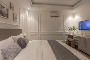 河内Keypad Hotel - 87 Nguyễn Khang的卧室配有一张白色大床和一台平面电视。