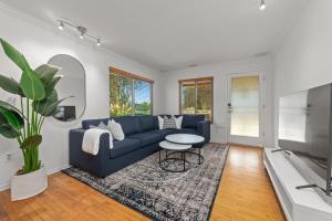 圣地亚哥Cali-Craftsman - 3BR - New Backyard - Central - AC的客厅配有蓝色的沙发和桌子