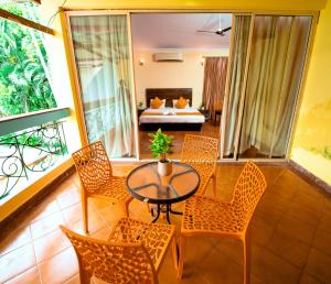 安君纳Atulyam Villa- Anjuna的客厅配有桌椅和1张床