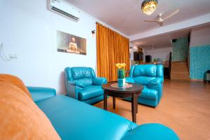 安君纳Atulyam Villa- Anjuna的客厅配有蓝色的家具和桌子