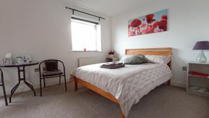 曼彻斯特Arena House的一间卧室配有一张床、一张桌子和一个窗户。