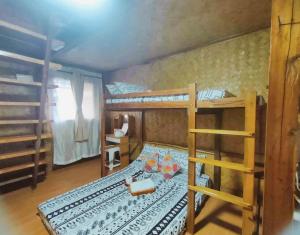 爱妮岛El Nido Backpackers Guesthouse的一间卧室设有两张双层床和一张桌子