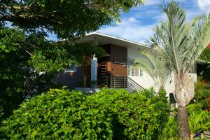 长滩岛One Hagdan Villas的前面有棕榈树的房子