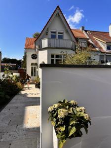 埃肯弗德Villa am Strand的房屋旁的白色墙,有盆栽