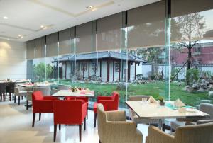 北京北京德胜门华宇假日酒店的餐厅设有桌椅和大窗户。