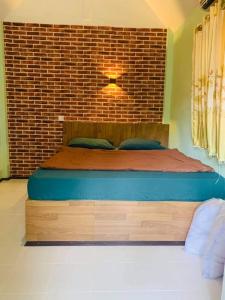 象岛cher lonely beach resort Koh chang的砖墙房间的一个床位
