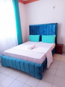 姆特瓦帕Bliss homestay apartment with swimming pool的一张带蓝色床头板的睡床