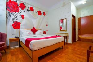 斋浦尔Hotel Parv的卧室配有一张墙上红色玫瑰床。
