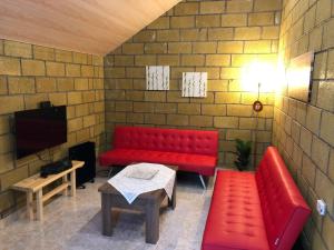 塞凡Tranquil Forest Retreat cozy Cottage near Sevan的红色的沙发和一张桌子