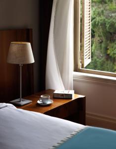 伊斯坦布尔汤姆套房酒店的一间卧室配有一张床、一张桌子、一盏灯和一扇窗户