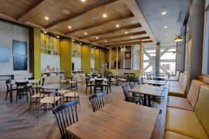 墨西卡利Fairfield Inn & Suites by Marriott Mexicali的餐厅设有木桌和椅子,墙壁为黄色