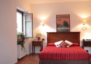 斯特雷萨拉罗卡达酒店的一间卧室配有一张红色床罩的床