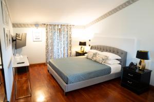 维泰博Relais Santa Caterina Hotel的一间卧室配有一张床和一张带台灯的书桌