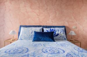 泰尔莫利A casa di Elga的一间卧室配有一张带两盏灯的蓝色床。